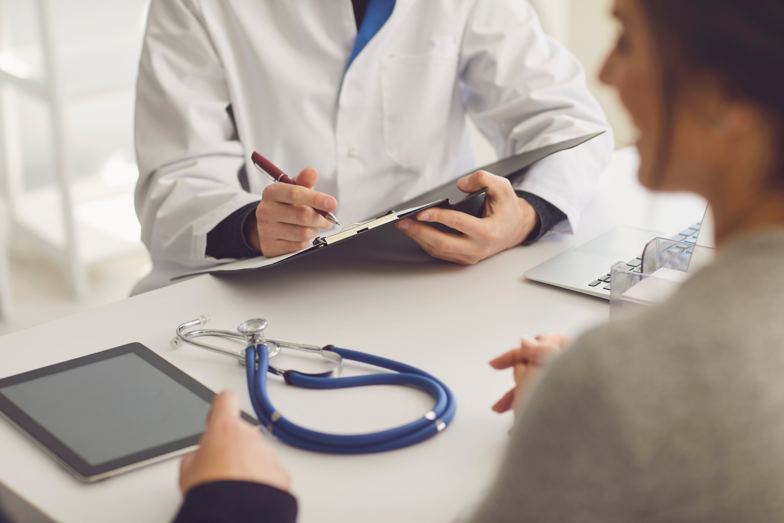 Un medico prende appunti durante una visita con una paziente